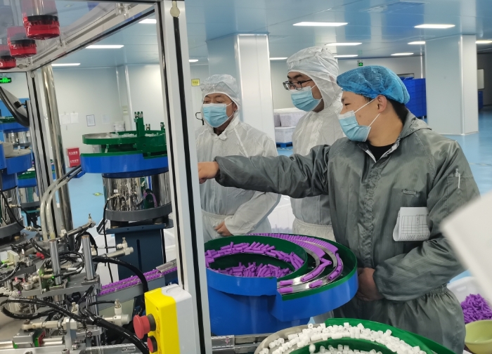 图为监管人员检查末稍采血针自动组装机。 图为监管人员检查末稍采血针自动组装机。